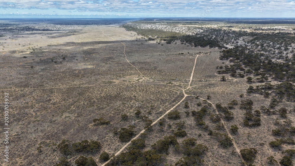 Fototapeta premium Madura, Western Australia – 4K aerial drone view of remote outback highway, arid landscape, bushland and vast inland plains
