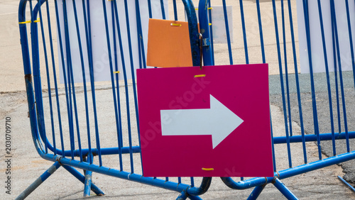 Right‑pointing arrow sign on metal barrier