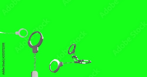 Metallic handcuffs fall dramatically against a vibrant green screen, symbolizing justice, crime, and security. This isolated element is perfect for various impactful productions.