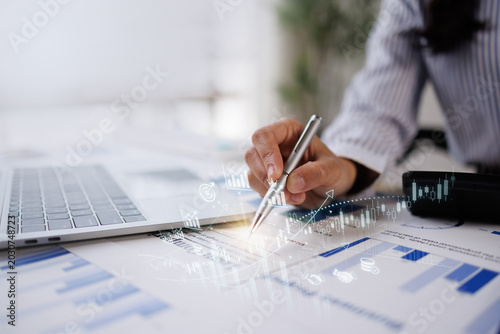 Hand og Many charts and graphs. Reflection light and flare. Concept image of data gathering and statistical working.