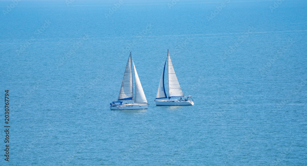 Fototapeta premium White sailboats on the blue sea 