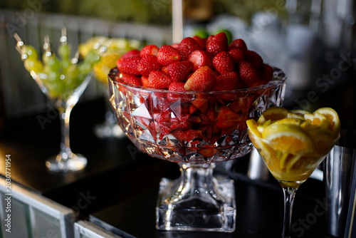 Chiseled glass goblet filled with vibrant red strawberries at an event bar counter