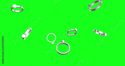 Elegant silver engagement and wedding rings, some sparkling, gracefully fall against a vibrant green screen. This versatile animation is perfect for romantic projects and easy chroma keying.