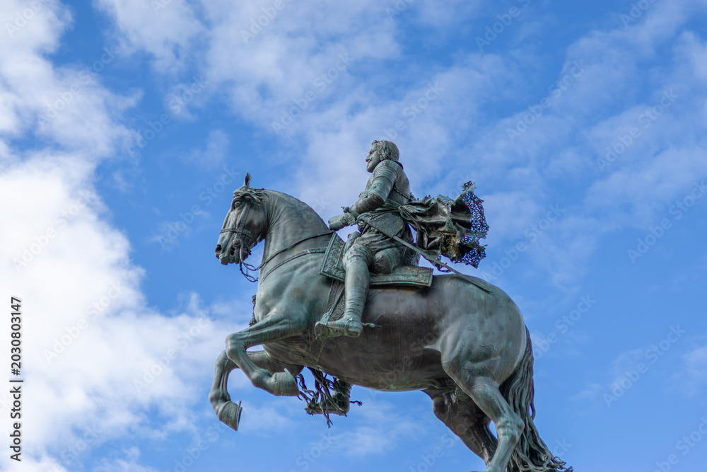 Fototapeta premium Bronze royal monument to Felipe IV against blue sky at Plaza de Oriente, Madrid, Spain