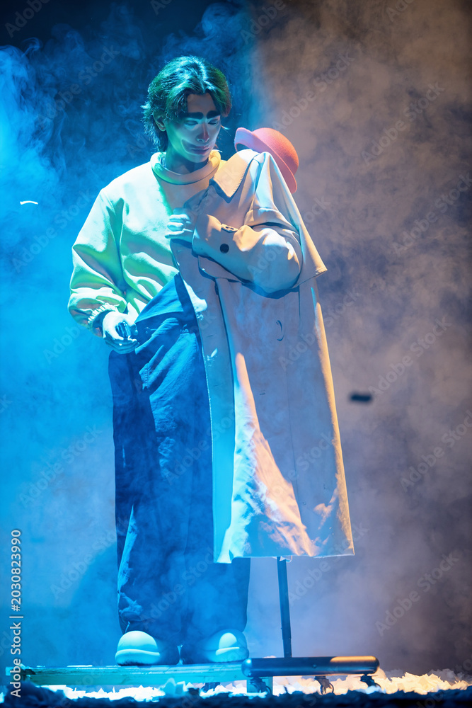 Obraz premium Clown-dressed comedians performing prop misdirection on stage