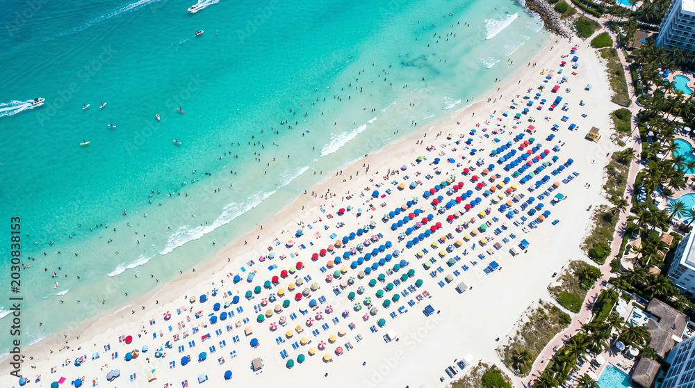 Fototapeta premium Summer Beach Aerial Diagonal View with Turquoise Water, Colorful Umbrellas, Water Sports and Hotel Buildings