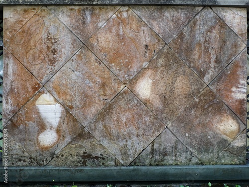 Photography Close-up architectural shot of a modern dark grey stone wall panel featuring textured horizontal rectangular slate blocks and a distinct linear geometric layout under soft daylight