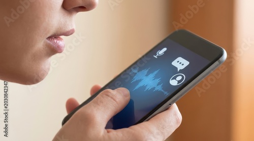 Person using voice assistant on mobile phone, showing sound wave on screen.