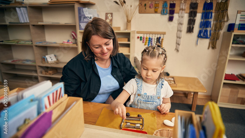 Foto Quiet child building pattern from natural objects during preschool sensory lesson