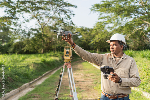 Engineer preparing drone for land surveying with total station