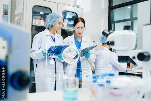 Photos Medical scientists performing biotechnology laboratory research with DNA molecul