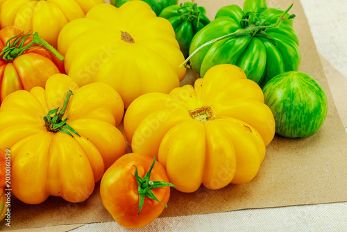 Φωτογραφία A vibrant flat lay of various homegrown heirloom tomatoes, including large ribbe