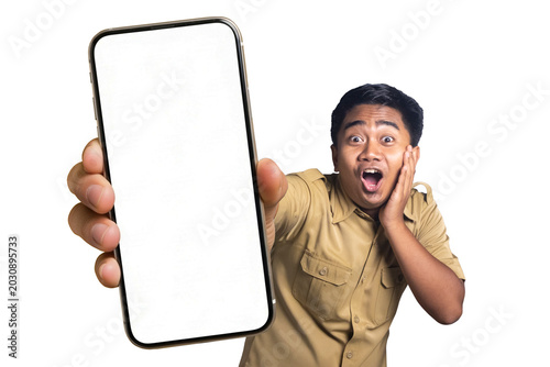 Foto Indonesian civil servant looking at camera with shocked wow expression holding huge blank phone mockup