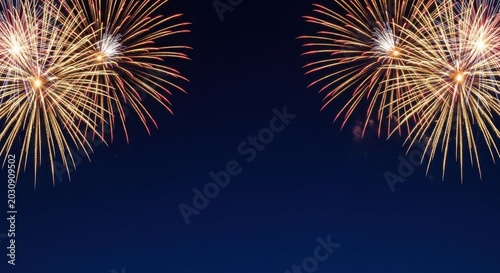 Vibrant fireworks explode in night sky with golden and red sparks
