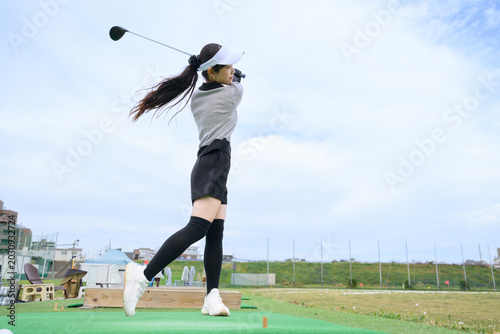 Photos ゴルフのスイングをする日本人女性