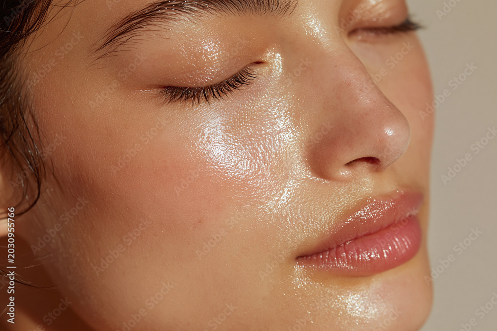 Fototapeta premium Hydrated radiant skin soft glow close up portrait with closed eyes and natural makeup showing dewy complexion and smooth texture, serene expression and gentle warm lighting