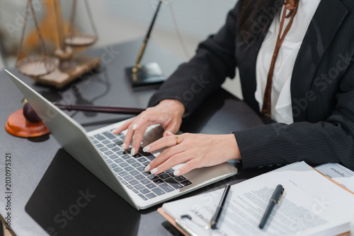 Legal Professional at Work: A close-up shot captures a legal professional typing on a laptop, surrounded by documents, a gavel, and the scales of justice.