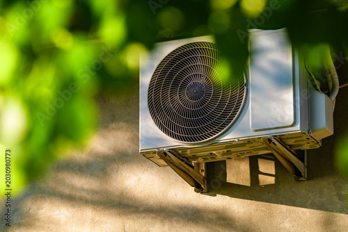 Air conditioning, heating against the background of leaves