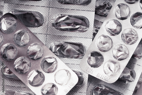 Pile of empty blister packs of pills close up. Concept of medical waste management, environmental pollution by plastic pharmaceutical packaging, expensive healthcare cost and end of treatment. Macro.