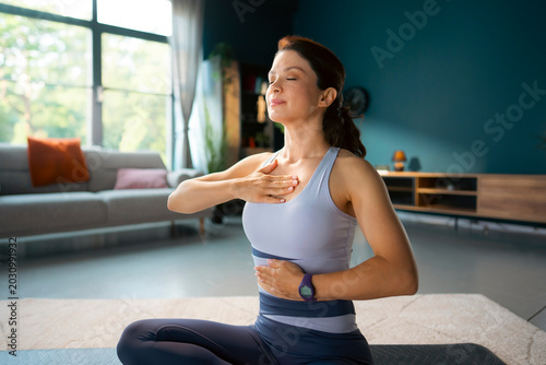 Foto A woman sits on a yoga mat in a well-lit room