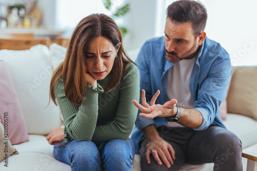 Upset Woman and Man Arguing on Couch During Relationship Conflict at Home