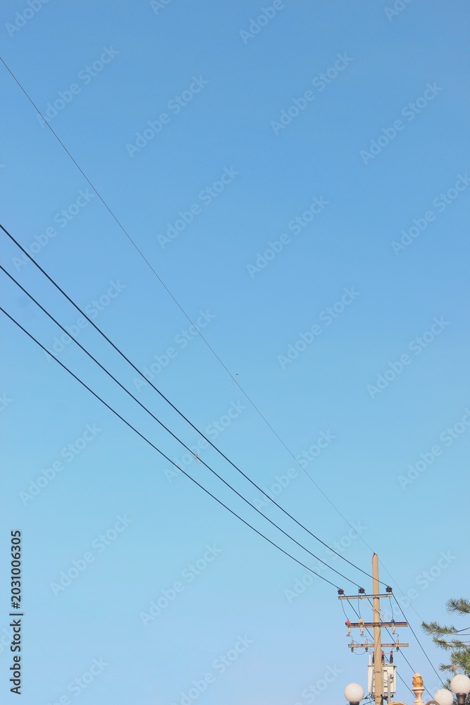 Fototapeta premium electric power lines against clear blue sky background