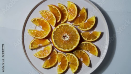 Fresh orange slices arranged in a sun pattern on a white plate