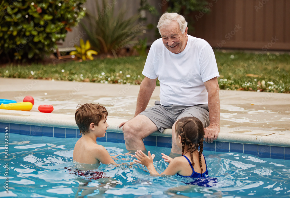 Fototapeta premium Grandfather caring for grandkids at summer pool