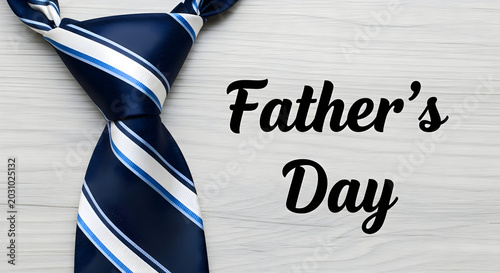 Father's day celebration with navy blue and white striped tie on wooden background