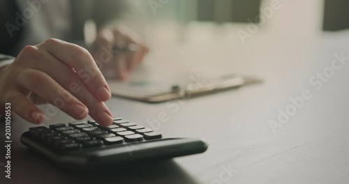 Close-up view woman's hand using a calculator