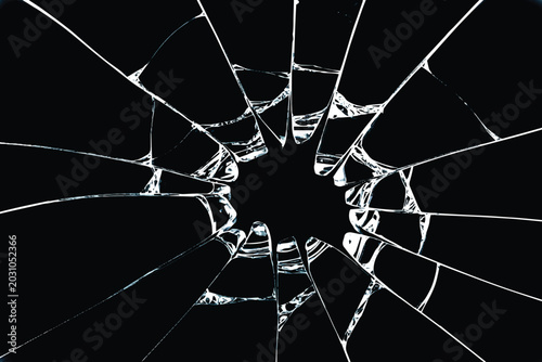 Broken window glass effect with radial sharp shards and cracks from impact,Shattered glass texture with bullet hole crack pattern isolated on black background.