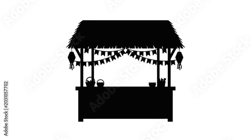 Silhouette of tropical beach hut with thatched roof and hanging decorations