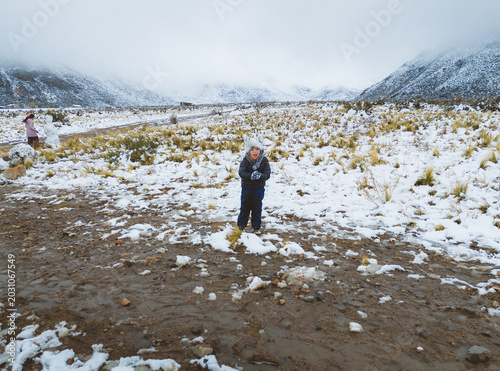 child playing in the snow in snowy field