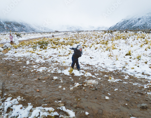 child playing in the snow in snowy field