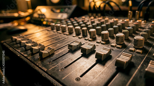 Professional Audio Mixing Console with Faders and Knobs in a Recording Studio