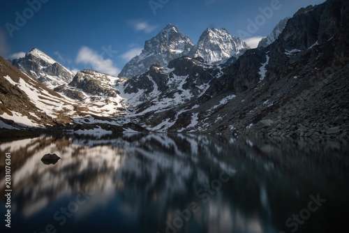 Fotografi The Monviso mountain range (or Mount Viso) reflected in the crystal-clear waters of Lake Fiorenza at sunset on a spring day, Monviso Natural Park, Po Valley, Piedmont, Italy