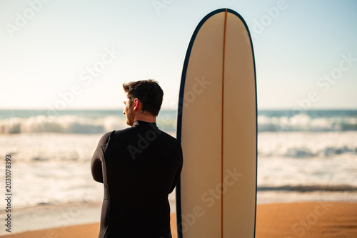 Obraz na płótnie Surfer in wetsuit looking at ocean waves