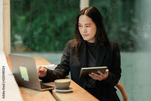 Hardworking accountant managing physical receipts and entering financial data into a spreadsheet on a computer, symbolizing financial literacy.