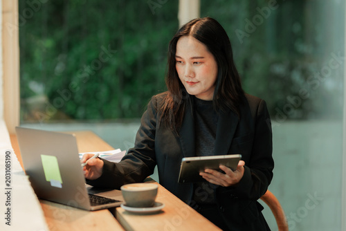 Hardworking accountant managing physical receipts and entering financial data into a spreadsheet on a computer, symbolizing financial literacy.