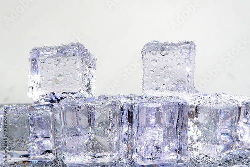 Εκτύπωση καμβά Close-up photograph of melting ice cubes covered in water droplets, showcasing their transparent, crystalline structure and the refreshing coolness they represent for beverages and cooling needs