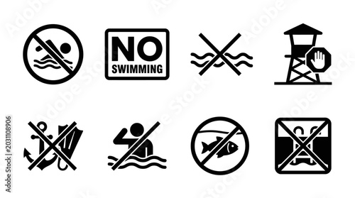 Photos A set of black and white warning signs prohibit swimming and fishing in a restricted area near a lifeguard tower