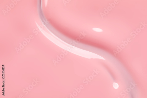 Pink nail polish as background, top view
