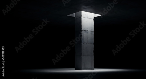 Minimalist concrete pillar in dark room with overhead dramatic light