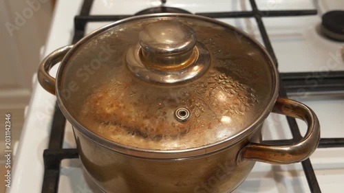 Meat cutlets are stewed in saucepan. A saucepan with a closed lid. Cooking, stewing meat. Meat patties are cooked in metal cooking pot with boiling water