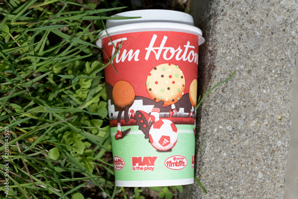 Naklejka premium Tim Hortons soccer themed beverage cup discarded outside, Toronto