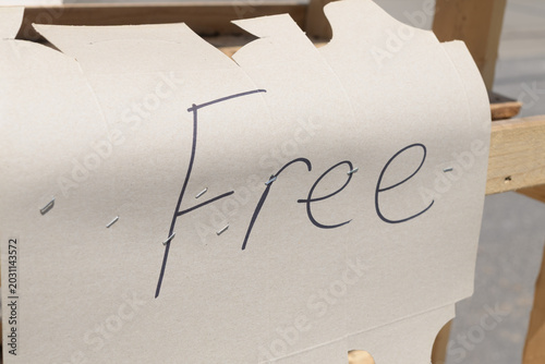 Photos handwritten sign with the letters on plain brown cardboard outside