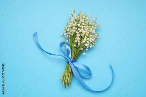 Foto Bouquet of gentle lily-of-the-valley flowers on light blue background, top view