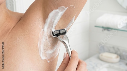 Close Up of Woman Shaving Underarm Hair with Razor and Shaving Foam Bathroom Body Care Hygiene Concept
