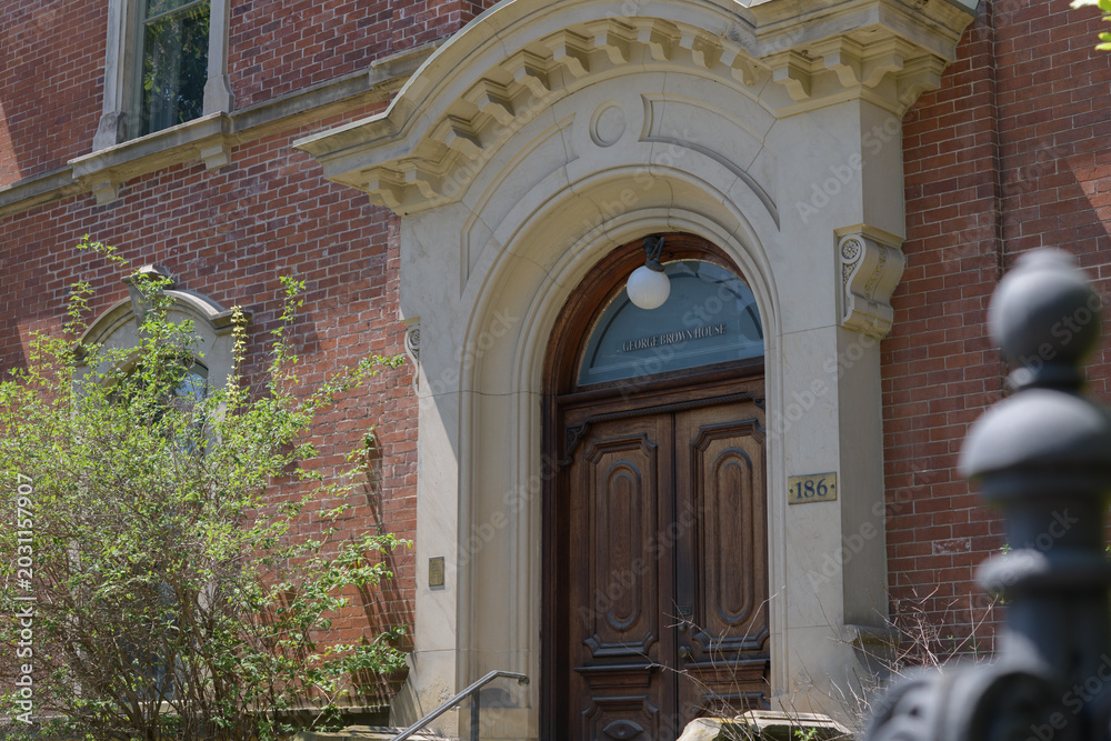 Naklejka premium entrance portal with stone frame and sign at George Brown House located at 186 Beverley St, Toronto