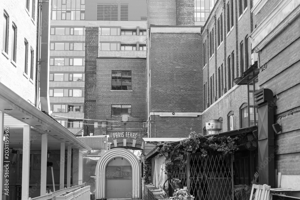 Naklejka premium black and white view of long walk to entrance of Paris Texas, a bar, located at 461 King St W, Toronto